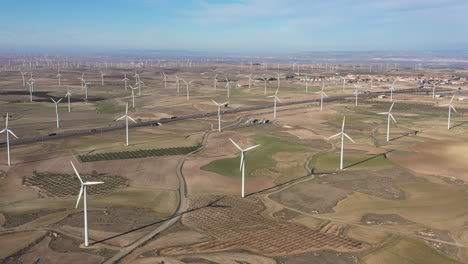 Straße-Inmitten-Von-Feldern-Mit-Windkraftanlagen-Sonniger-Tag-Spanien-Luftaufnahme